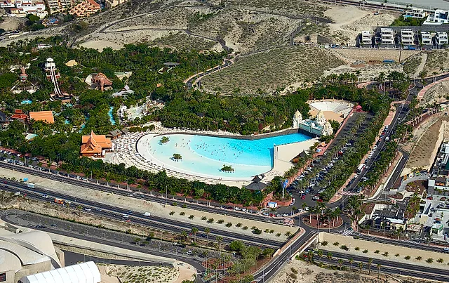 Aerial view of Siam Park with its large wave pool surrounded by gardens and the road below